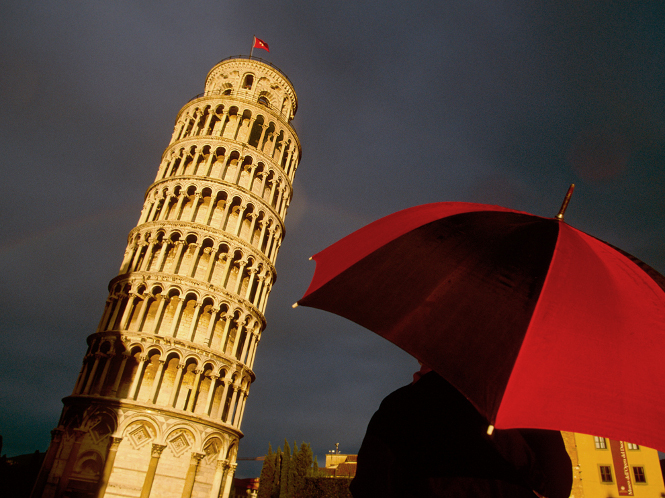 Tourist looking at the famous leaning tower of Pisa after rain.