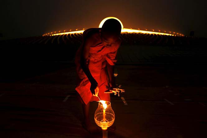 Ένας βουδιστής μοναχός ανάβει ένα κερί κατά την τελετή στη Wat Phra Dhammakaya, την ημέρα Makha Bucha στην επαρχεία Pathum Thani, βόρεια της Μπανγκόκ, στις 22 Φεβρουαρίου 2016. REUTERS/Jorge Silva 
