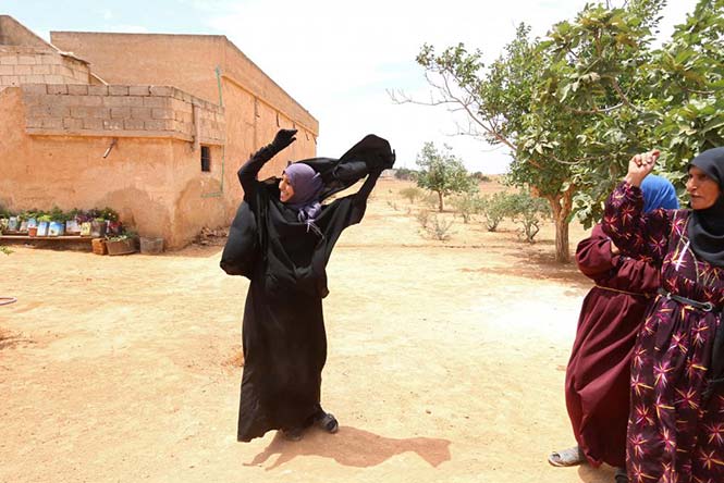 Μία γυναίκα αφαιρεί τη μαντήλα Niqab που φορούσε, μόλις οι Συριακές Δημοκρατικές Δυνάμεις (SDF) ανέλαβαν τον έλεγχο του χωριού της, κοντά στη πόλη Manbij, στην επαρχία Aleppo της Συρίας, στις 9 Ιουνίου 2016. REUTERS/Rodi Said 