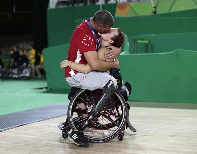 Ο Καναδός παίχτης καλαθοσφαίρισης με αναπηρικό καροτσάκι Adam Lancia αγκαλιάζει τη γυναίκα του Jamey Jewells μετά το παιχνίδι της με την ομάδα γυναικών του Καναδά στο άθλημα της καλαθοσφαίρισης με αναπηρικό καρότσι εναντίον της Κίνας στα playoff των ΠαραΟλυμπιακών Αγώνων του Ριο. REUTERS/Ueslei Marcelino 