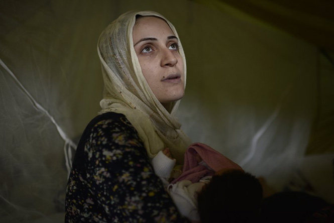 Μία Σύρια πρόσφυγας, κρατάει το νεογέννητο μωρό της, σε ένα προσφυγικό καταυλισμό στη Θεσσαλονίκη, 26 Σεπτεμβρίου 2016. Lynsey Addario—Getty Images reportage for TIME 