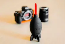 Φυσητήρας χειρός καθαρισμού κάμερας σε πρώτο πλάνο, με σώμα και φακό στο φόντο