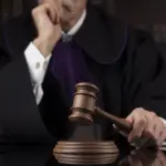 Δικαστής κρατά σφυρί δικαστηρίου, σύμβολο δικαιοσύνης και νομικών αποφάσεων