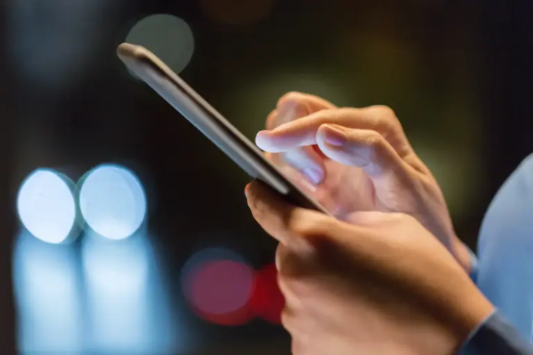 Χρήση smartphone με φωτισμένη οθόνη σε χαμηλό φωτισμό