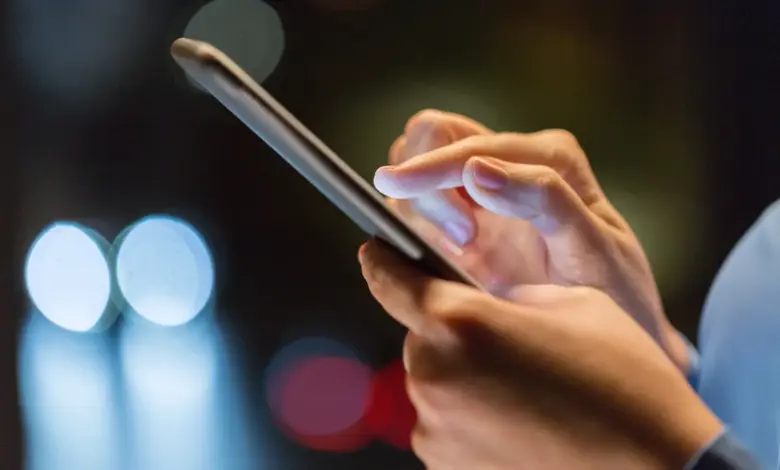 Χρήση smartphone με φωτισμένη οθόνη σε χαμηλό φωτισμό