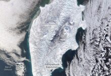 Δορυφορική εικόνα της Καμτσάτκα καλυμμένης από πυκνό χιόνι με ορατά ηφαίστεια και σύννεφα