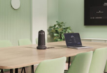 Meeting Owl 5 Pro τοποθετημένο στο κέντρο αίθουσας συσκέψεων με συμμετέχοντες γύρω από τραπέζι