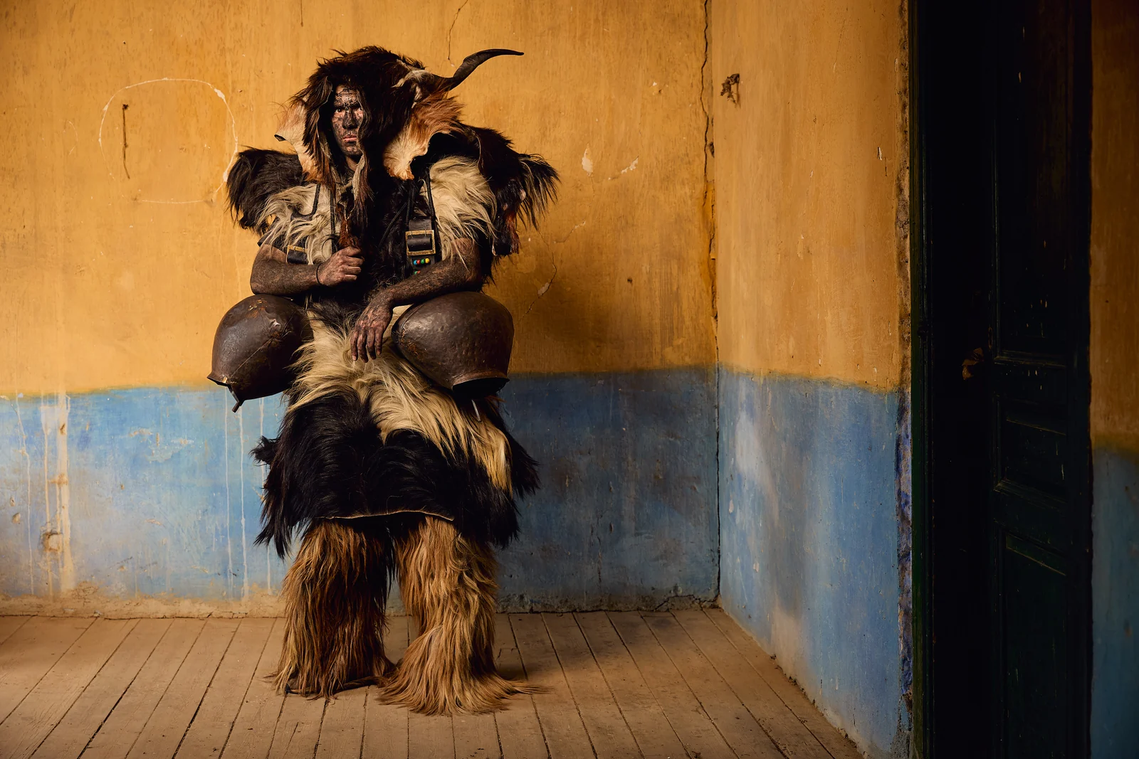 Arapis participant wearing animal skins and large bells at Babinten