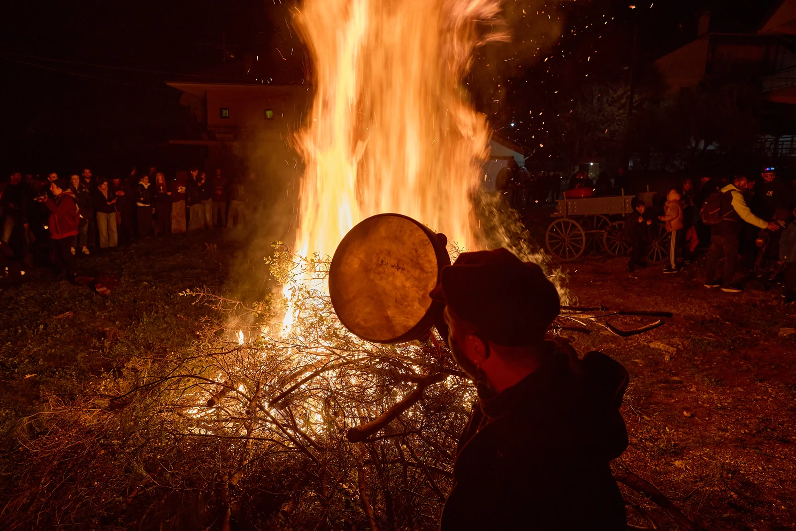 Musician with a ntahare frame drum in front of a large fire in Petrousa