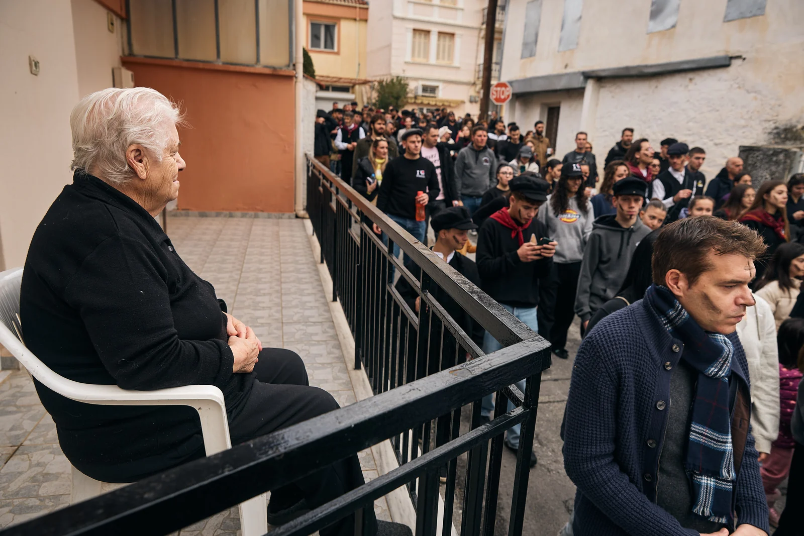 Elderly woman watches the Babinten procession pass her home