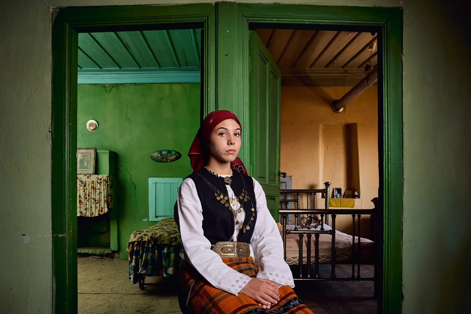 Young woman in traditional dress inside a Petrousa home