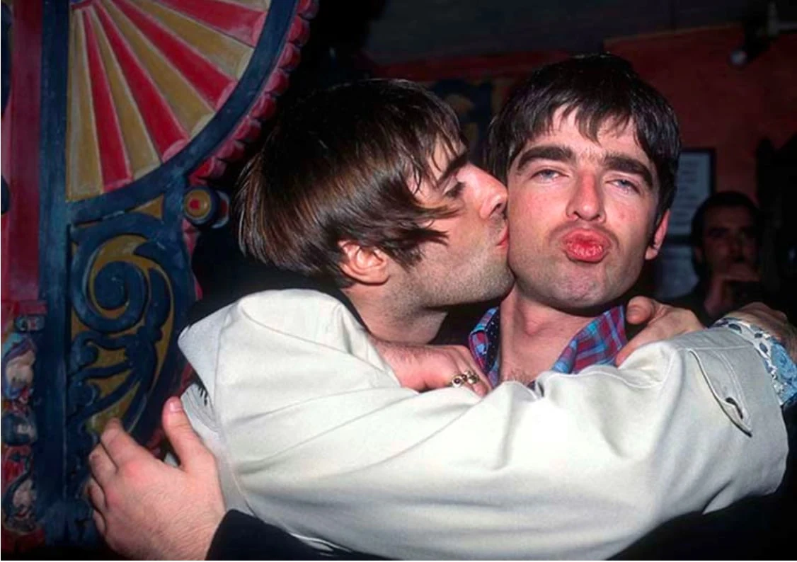 Ο Liam Gallagher φιλά τον Noel Gallagher στο μάγουλο στη φωτογραφία του Justin Thomas από το Earl’s Court το 1995