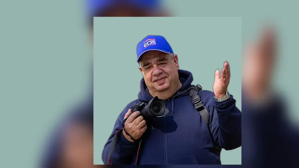 Ο Παύλος Ζαμενόπουλος κρατά φωτογραφική μηχανή.