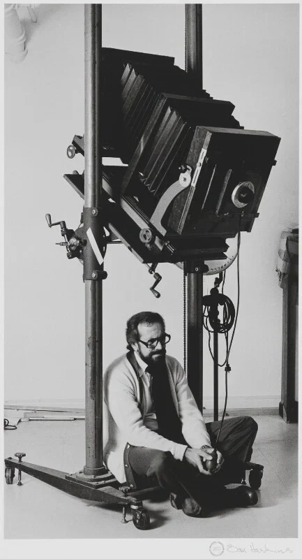 Ο Sam Haskins καθισμένος στο στούντιο κάτω από μεγάλη φωτογραφική μηχανή