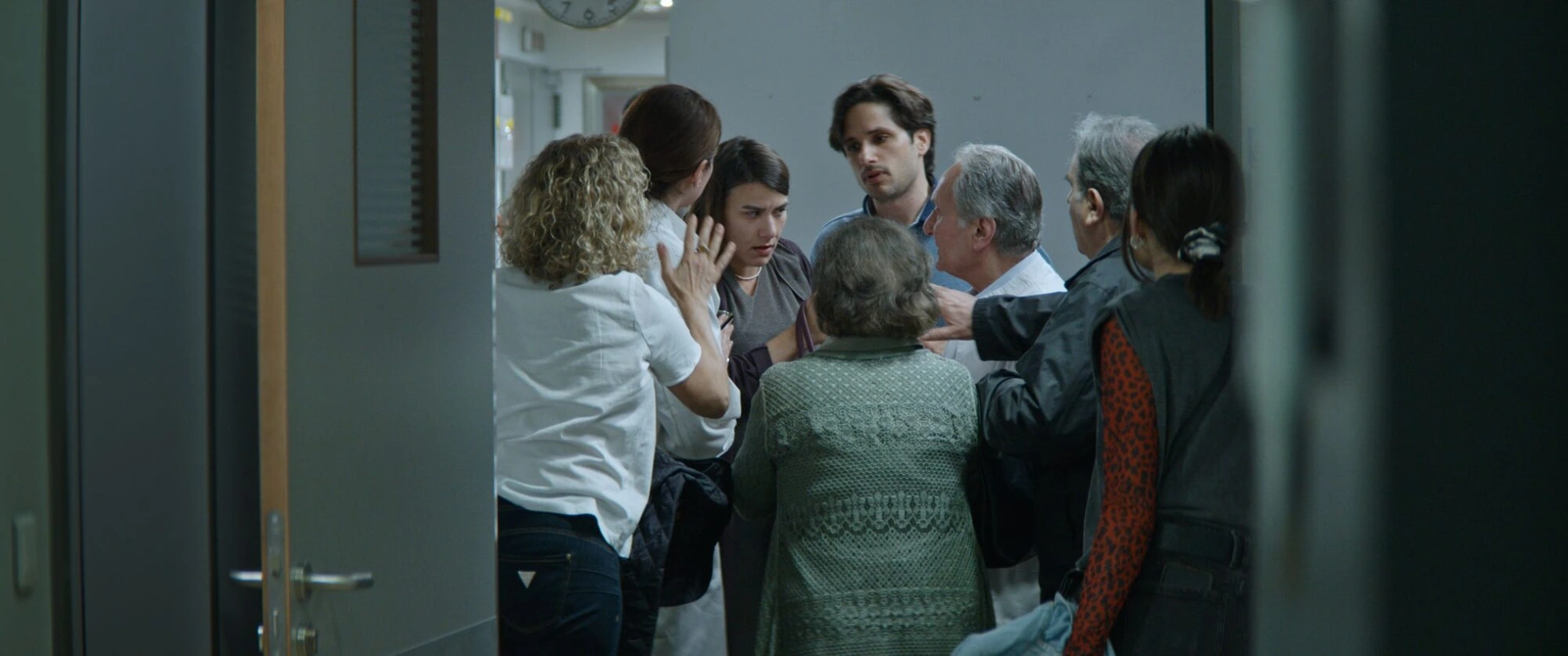 A group of people gathered in a corridor in a scene from the film
