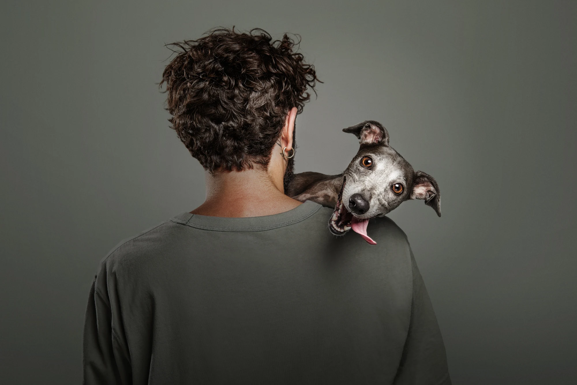 A dog rests its head on a person’s shoulder in Santos Román’s The Weight of Connection