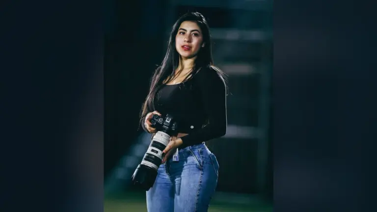Η φωτογράφος Adriana Caballero με φωτογραφική μηχανή Canon και λευκό τηλεφακό σε γήπεδο