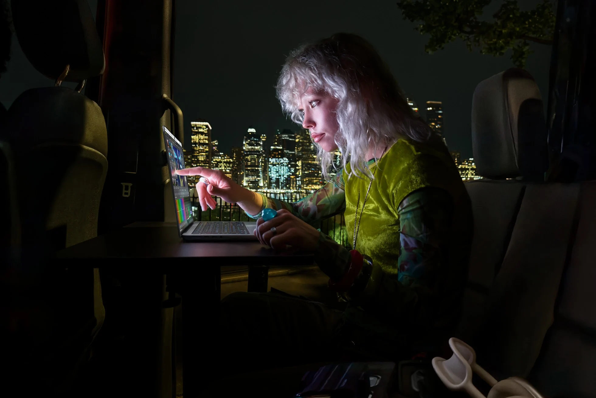 Άτομο χειρίζεται την οθόνη αφής MacBook Pro τη νύχτα