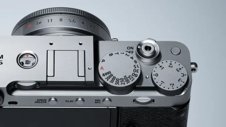 Κοντινή λήψη της επάνω πλευράς μιας ασημί Fujifilm X-E5 με επιλογείς και χειριστήρια