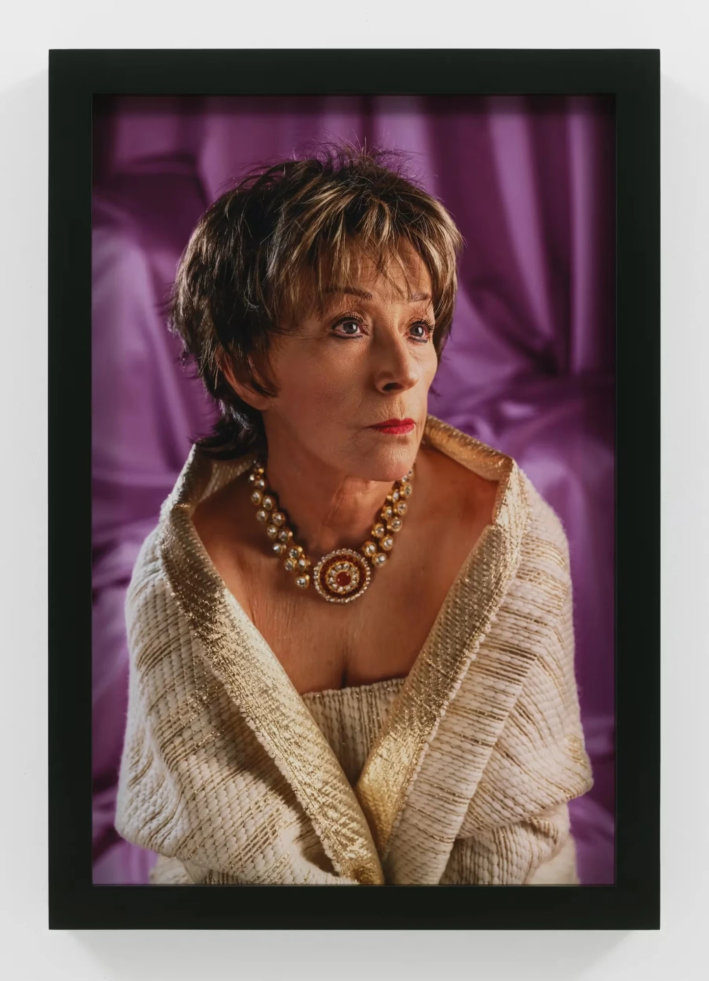 Σκηνοθετημένο πορτρέτο της Cindy Sherman με κοντή περούκα, κόσμημα και μοβ κουρτίνα