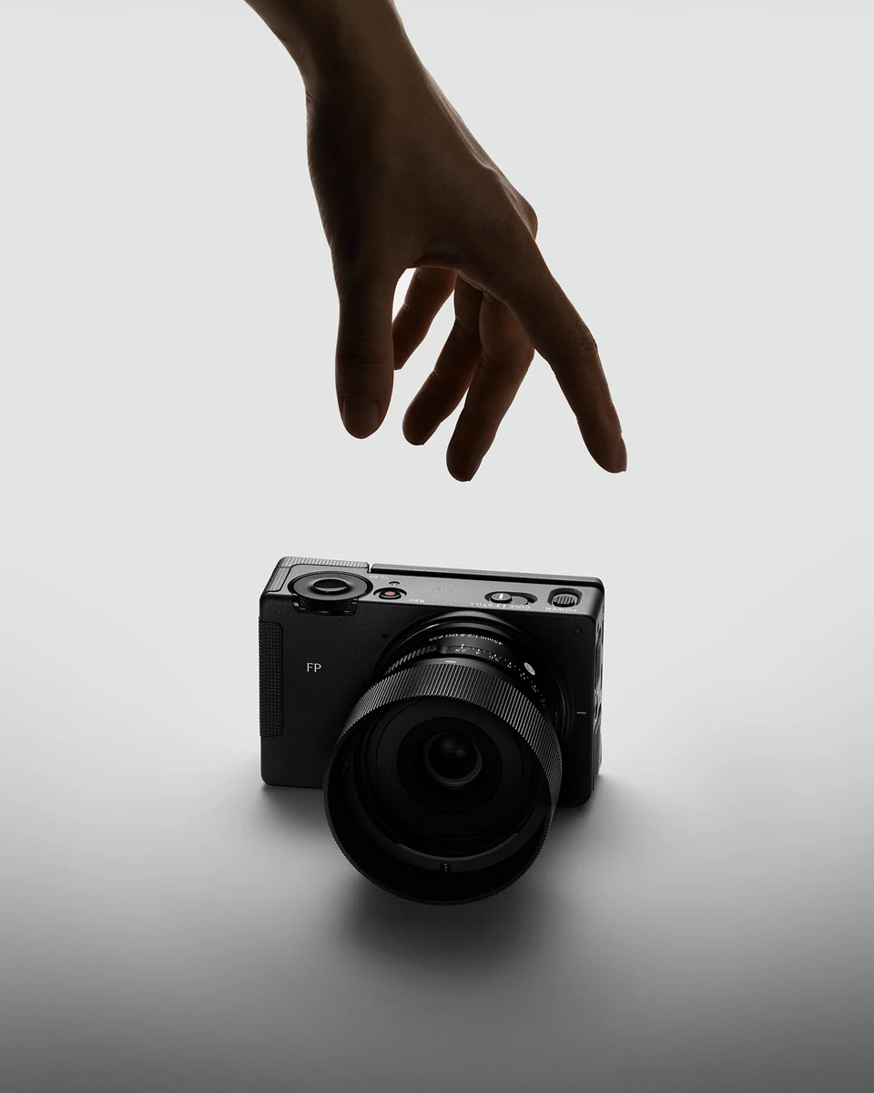 Sigma FP2 below a reaching hand in a campaign image