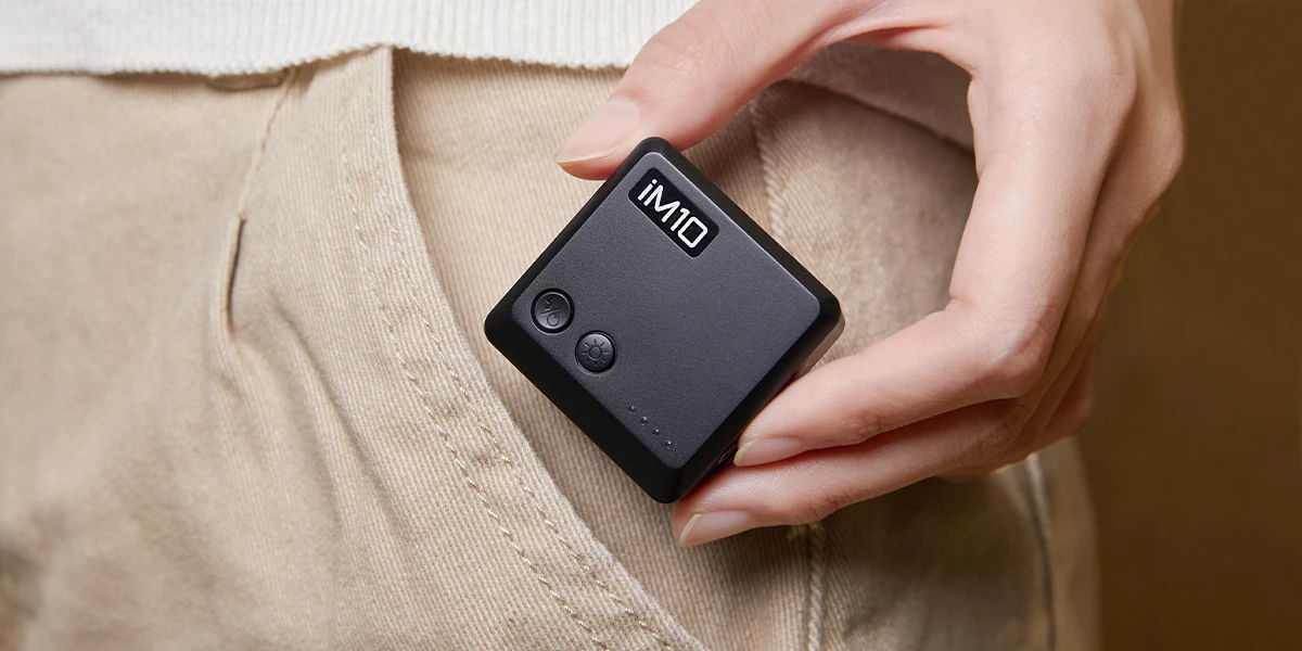 Small Godox iM10 flash held by hand beside a pocket