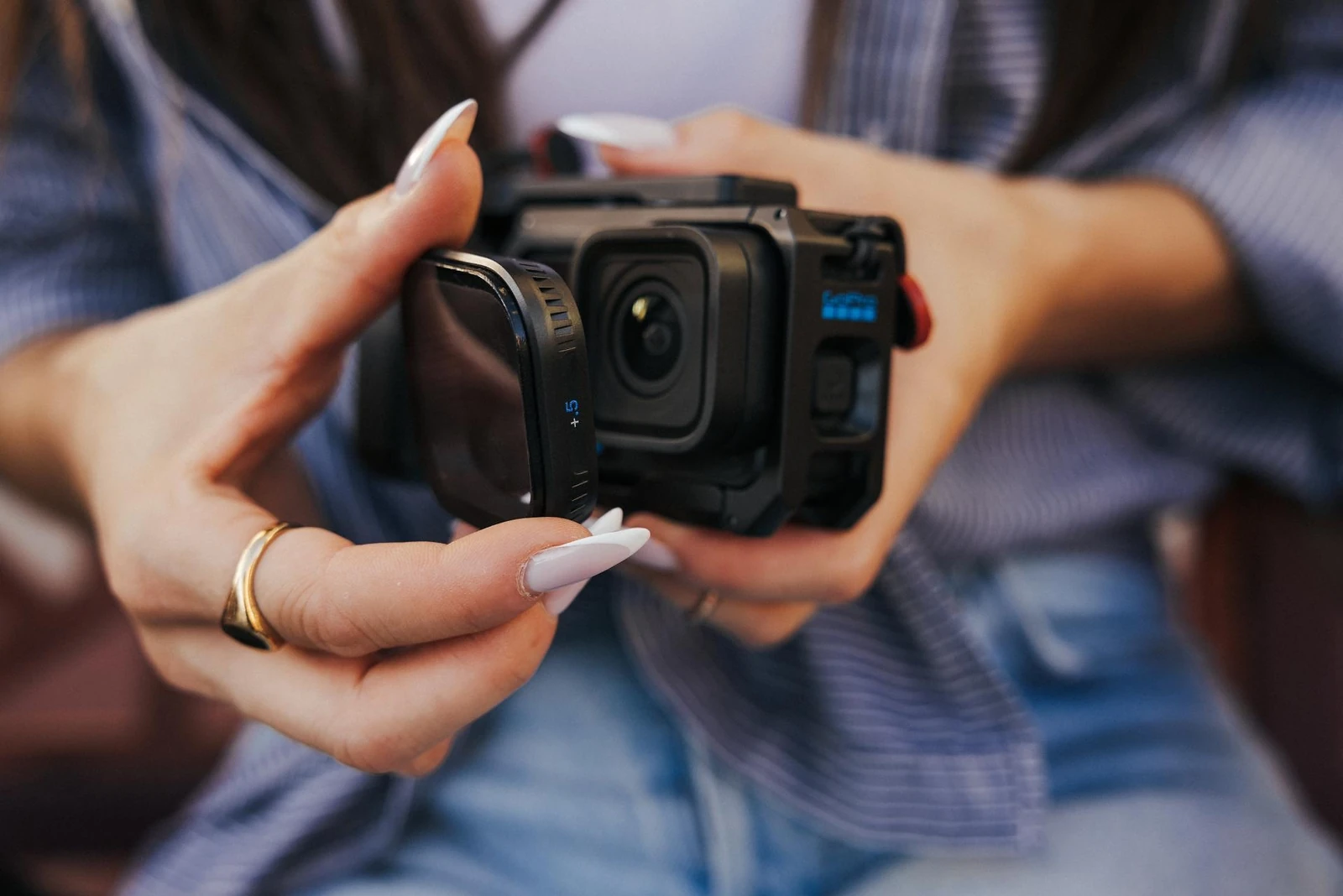 Person fitting a PolarPro Close-Up Filter to a GoPro MISSION 1 camera