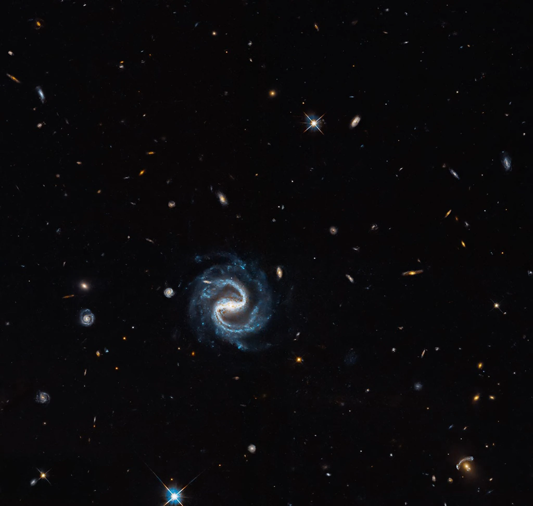 Ανεπεξέργαστη από γραφικά σύνθεση πεδίου Hubble με τον γαλαξία Z 43-83 στο κέντρο και τον βαρυτικό φακό κάτω δεξιά