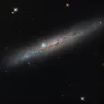 Γαλαξίας NGC 1827 από το πλάι, με καφετιές λωρίδες σκόνης, γαλάζιες περιοχές και φωτεινά άστρα προσκηνίου