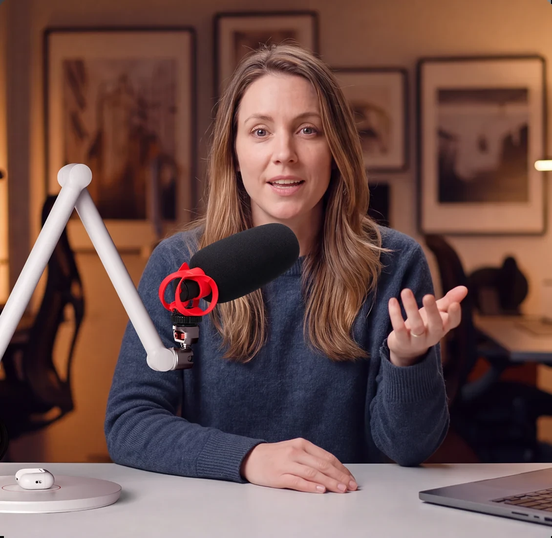 Woman speaking into a microphone supported by a white iFootage RB200 articulated arm