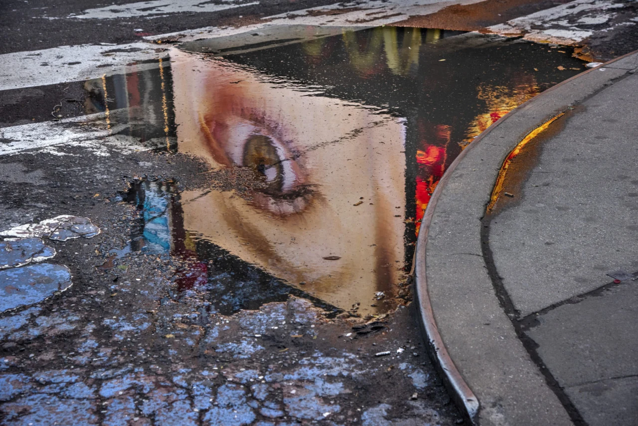 Πολύχρωμη αντανάκλαση ανθρώπινου προσώπου σε λακκούβα