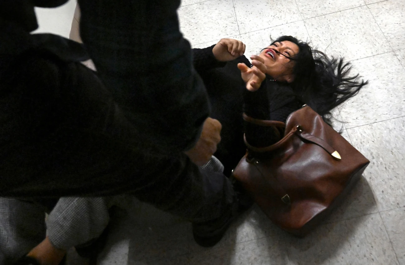 Άνδρας στο δάπεδο ενώ άλλοι τον συγκρατούν