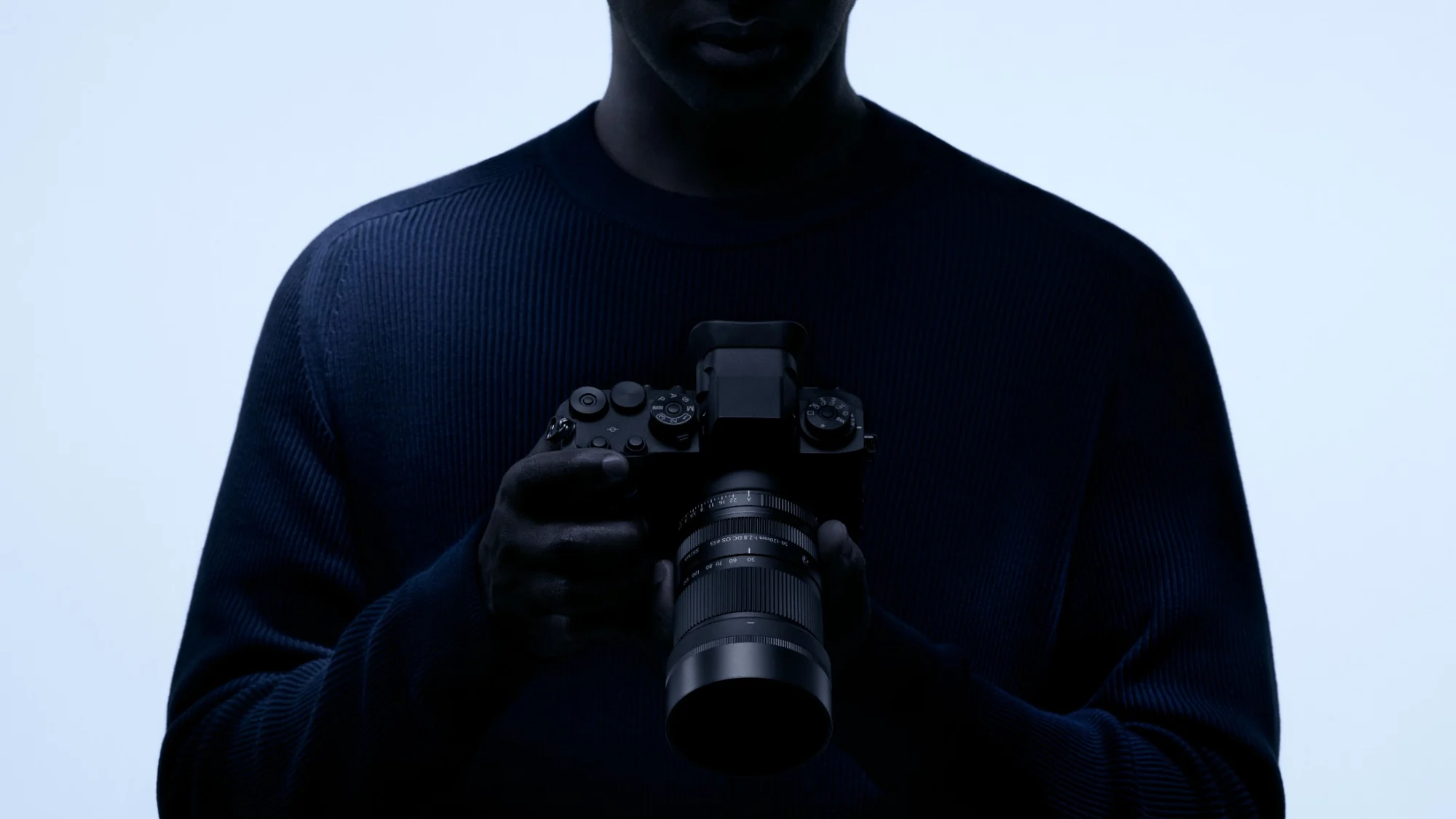 Φωτογράφος κρατά κάμερα με τον φακό Sigma 50-120mm F2.8