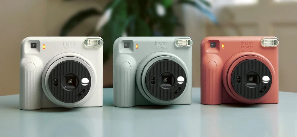 Τρεις εκδόσεις της Fujifilm instax SQUARE 2 πάνω σε τραπέζι