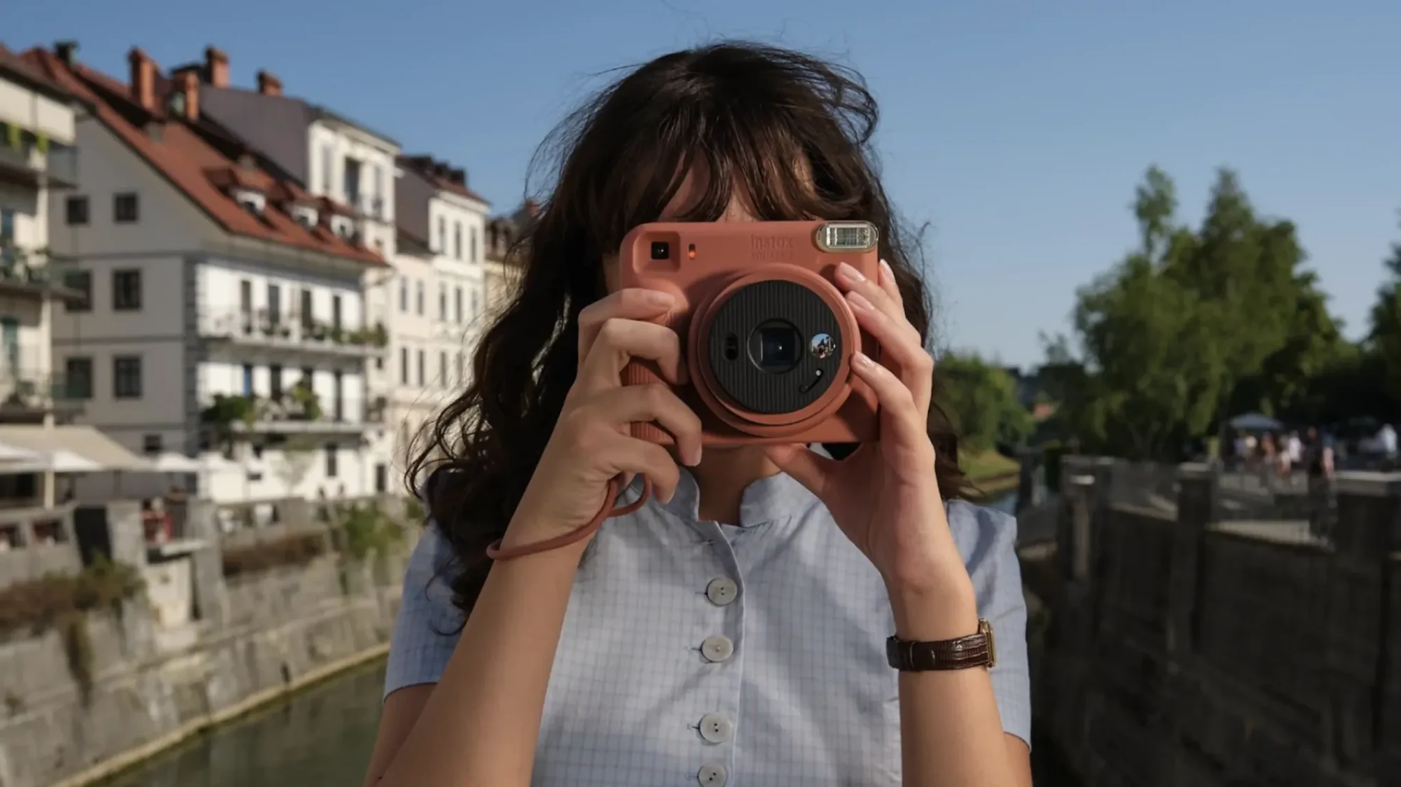 Γυναίκα φωτογραφίζει με την κόκκινη Fujifilm instax SQUARE 2