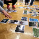 Φωτογραφίες απλωμένες στο πάτωμα κατά τη διάρκεια εργαστηρίου θεραπευτικής φωτογραφίας